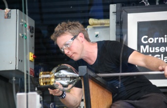 Gaffer Chris Rochelle works on a prototype by designer Judy Smilow for GlassLab at Governors Island