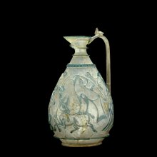 The Corning Ewer, Islamic, possibly Western Asia, possibly Egypt, about 1000.   Translucent pale green and colorless glass; blown, cased, relief-cut, drilled, handle applied H. 16 cm. Collection of The Corning museum of glass, purchased with funds from the Clara S. Peck Endowment (85.1.1) 
